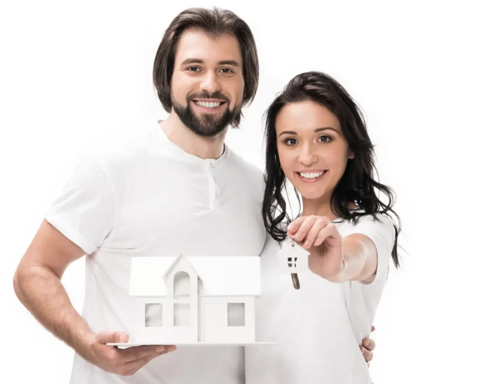 Couple souriant tenant une maquette de maison et une clé, symbolisant l’achat d’un chalet familial