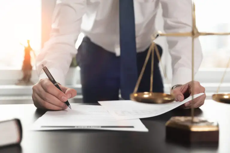 Signature d’un document encadré par la loi, avec balance de justice : protection légale en courtage immobilier.