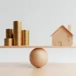 Balance entre maison et argent illustrant les intérêts opposés d’un vendeur et d’un acheteur en immobilier.
