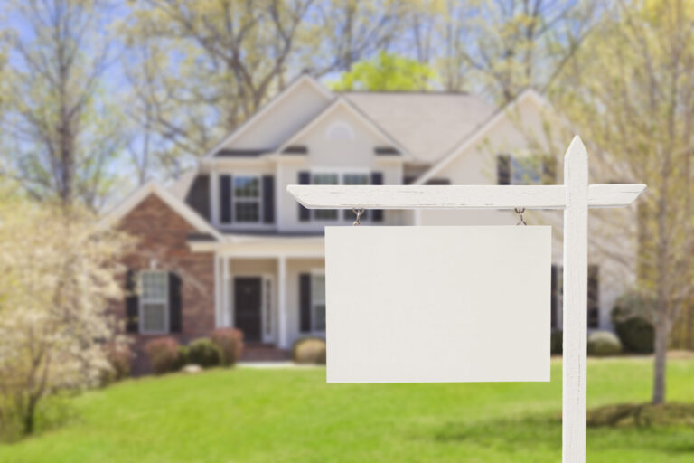 "Blank Real Estate Sign in Front of Beautiful New House - Ready for Your Own Text, Message or Logo."