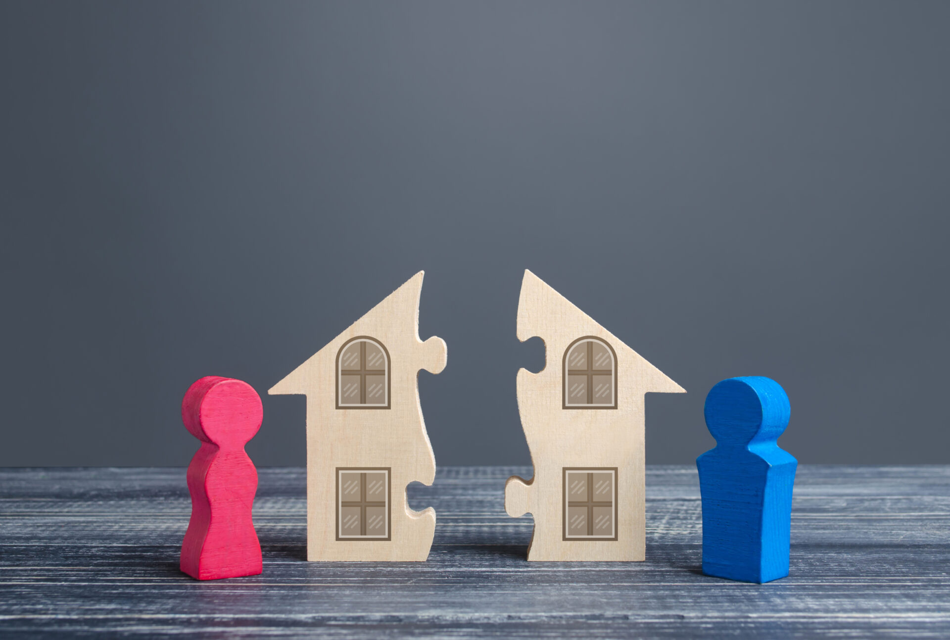 Maison divisée en deux morceaux de casse-tête entre un vendeur et un acheteur, illustrant un marché immobilier brisé par des pratiques qui séparent les intérêts au lieu de les protéger.