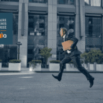 Courtier qui court pour livrer un document immobilier, symbolisant qu’une promesse d’achat doit être présentée sans délai.