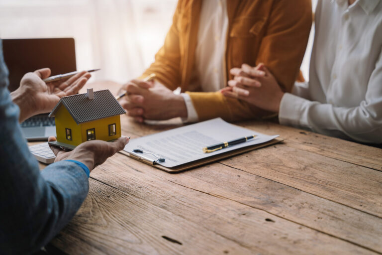 Discussion encadrée entre un courtier immobilier et des acheteurs autour d’un projet d’achat structuré sous Contrat de courtage achat